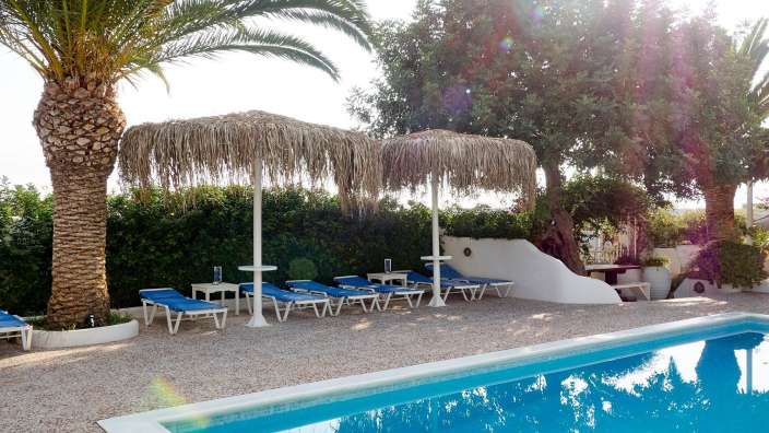 Liegestühle und Sonnenschirme neben einem Swimmingpool