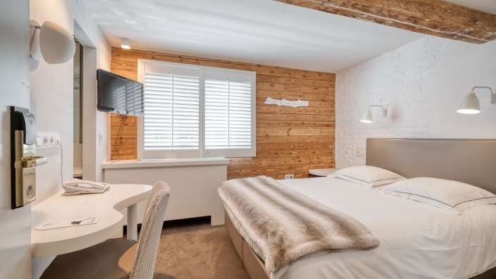 Ein Hotelzimmer mit einem Bett und einem Fernseher