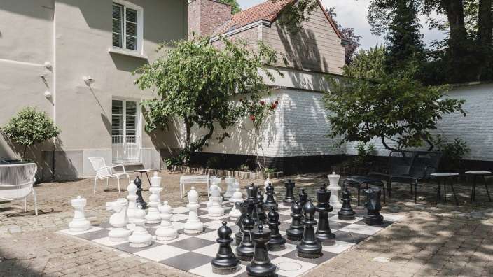 Ein Schachspiel auf einem großen Schachbrett in einem Garten