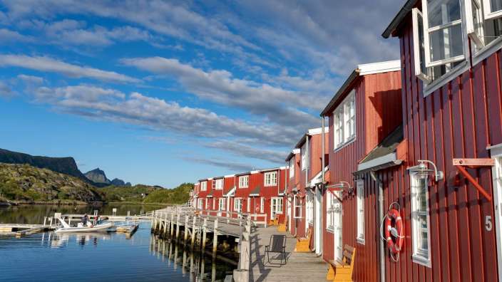 Eine Reihe von roten Häusern neben einem See