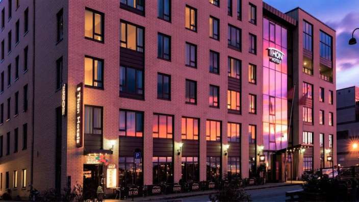Ein großes Backsteingebäude mit vielen Fenstern und der Aufschrift tron hotel