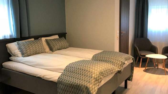 Ein Hotelzimmer mit zwei Betten und zwei Stühlen