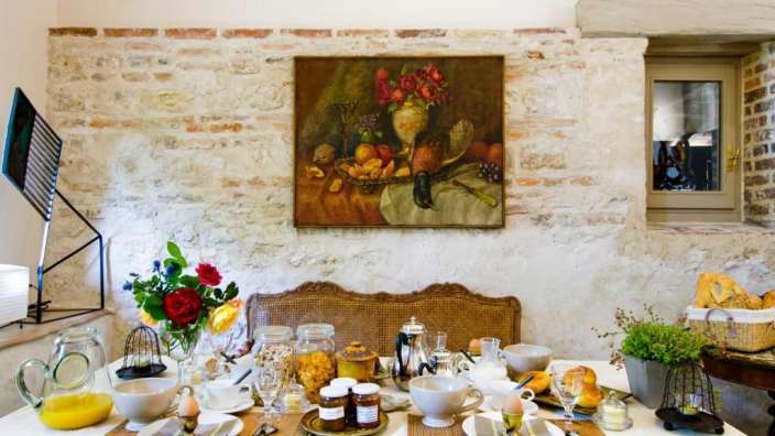 Ein Frühstückstisch mit einem Gemälde an der Wand darüber