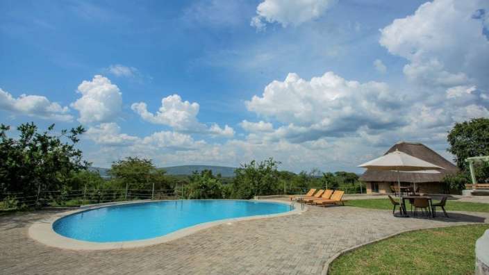 Ein großer Pool mit Liegestühlen und Sonnenschirmen um ihn