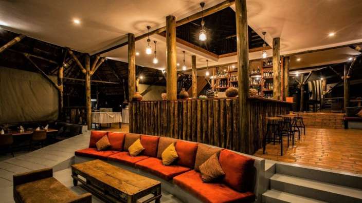 Ein Wohnzimmer mit roten und gelben Kissen und einem Holztisch