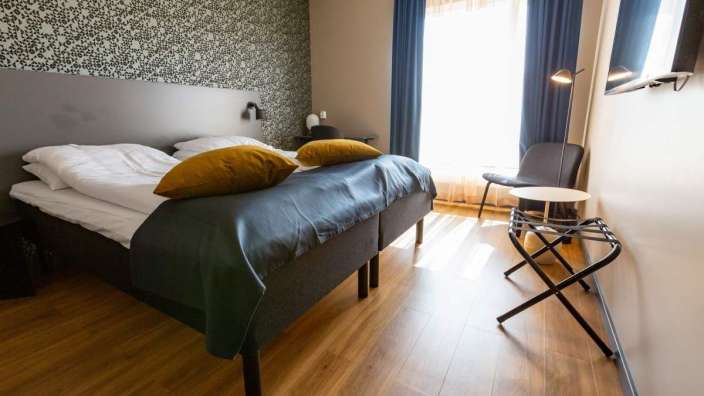 Ein Hotelzimmer mit zwei Betten und einem Stuhl