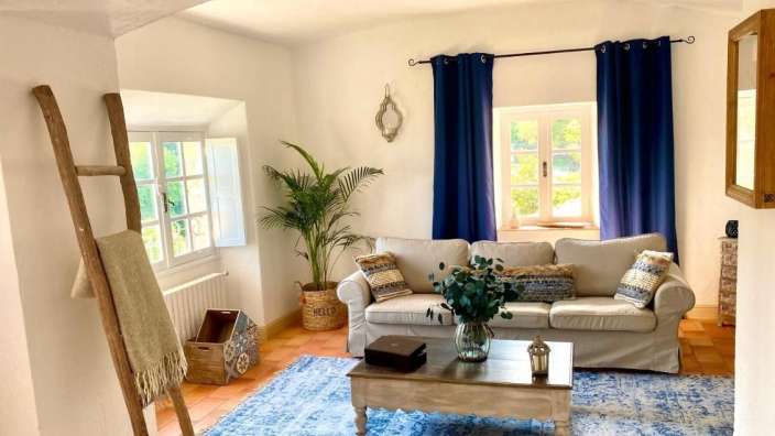 Ein Wohnzimmer mit einem weißen Couchtisch und blauen Vorhängen