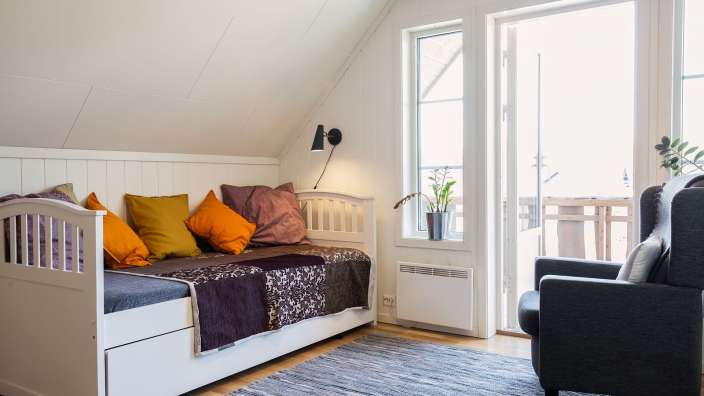 Ein Wohnzimmer mit einem Bett und einem Stuhl