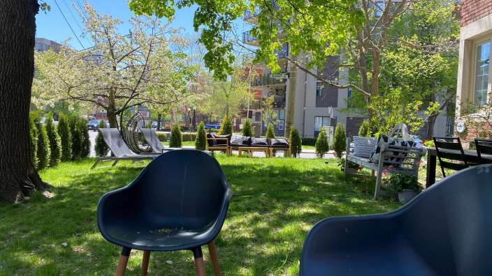 Ein paar schwarze Stühle sitzen auf einem grünen Rasen