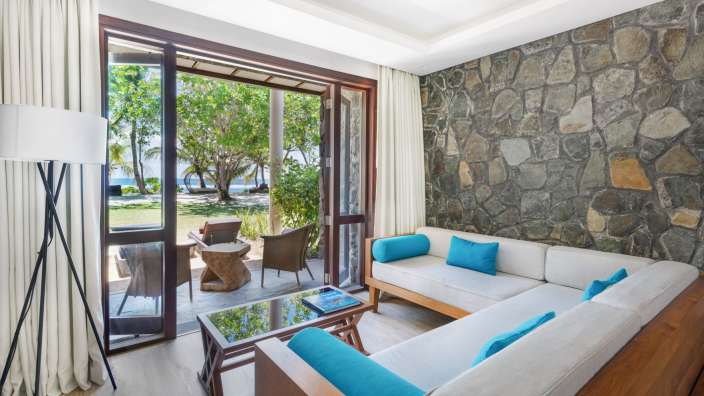 Ein Wohnzimmer mit einem weißen Couch und blauen Kissen