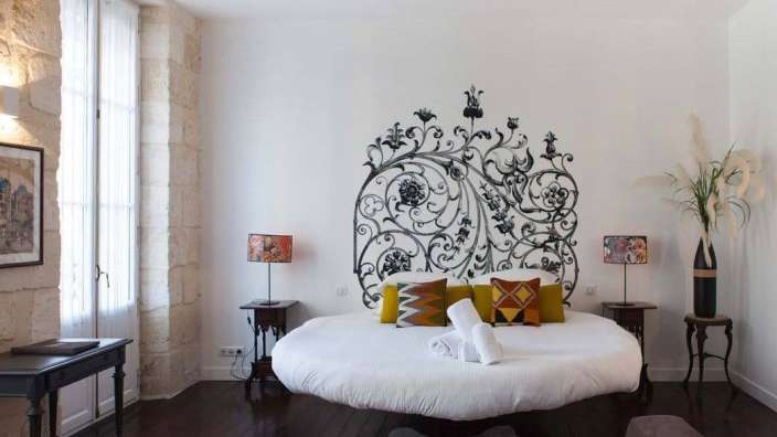 Ein Schlafzimmer mit einem runden Bett und einem dekorativen Kopfteil