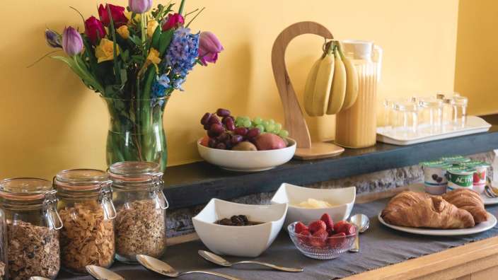 Ein Buffettisch mit verschiedenen Lebensmitteln und einer Vase mit Blumen