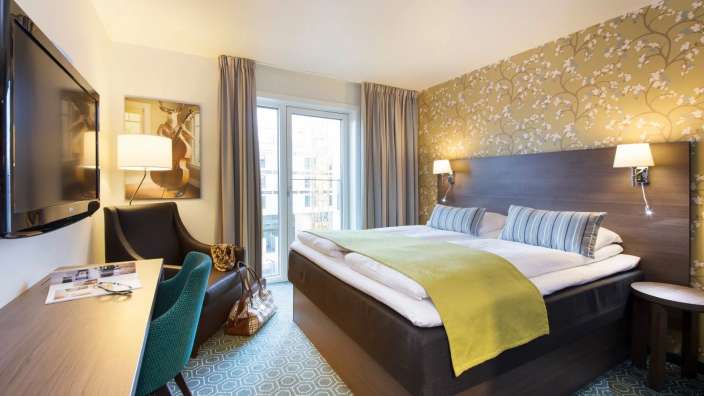 Ein Hotelzimmer mit einem Bett und einem Fernseher
