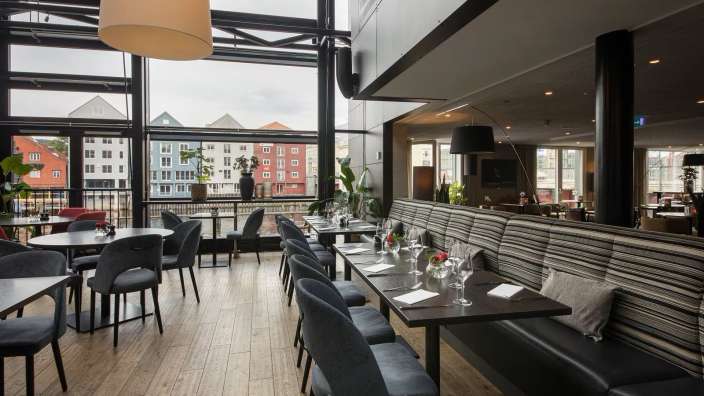 Ein Restaurant mit vielen Tischen und Stühlen und einem großen Fenster