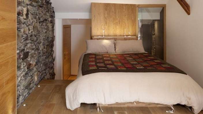 Ein Schlafzimmer mit einem Bett und einer Steinmauer