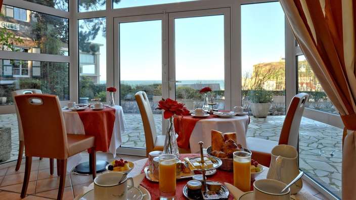 Ein Esszimmer mit einem Tisch und Stühlen und einem großen Fenster