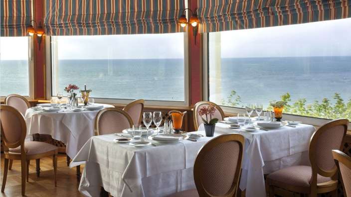 Tische und Stühle in einem Restaurant mit Blick auf das Meer