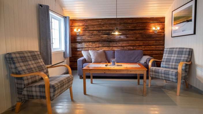 Ein Wohnzimmer mit einem Couchtisch und zwei Stühlen