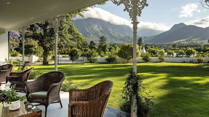 Eine Veranda mit Stühlen und einem Tisch mit Blick auf die Berge