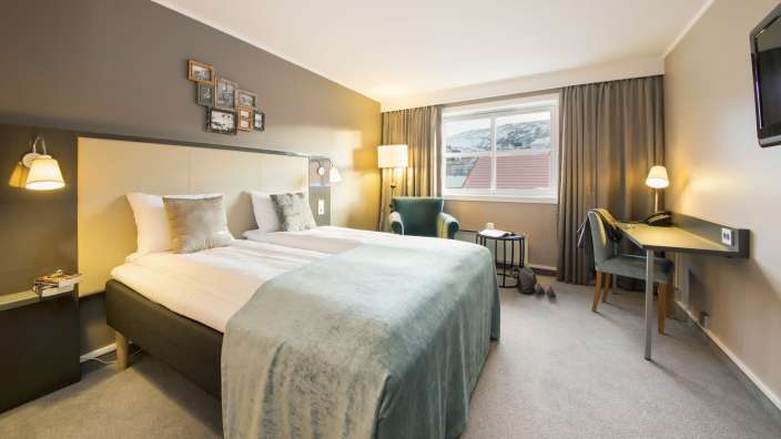 Ein Hotelzimmer mit zwei Betten und einem Stuhl