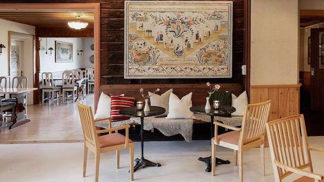 Ein Wohnzimmer mit Tisch und Stühlen und einem Gemälde an der Wand