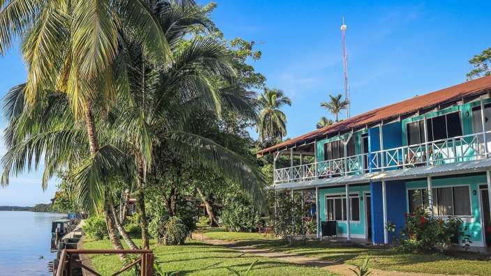 Ein blaues und grünes Gebäude neben einem Fluss