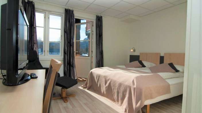 Ein Hotelzimmer mit einem Bett und einem Fernseher