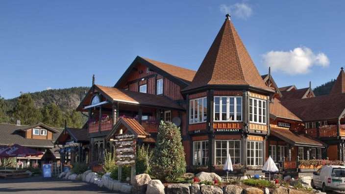Ein großes Gebäude mit einem Turm und einem Restaurant davor