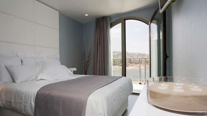 Ein Schlafzimmer mit einem Bett und einer Vase mit Kerzen darin