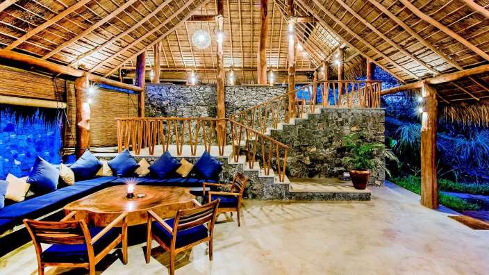 Ein Wohnzimmer mit blauen Kissen und einem Holztisch