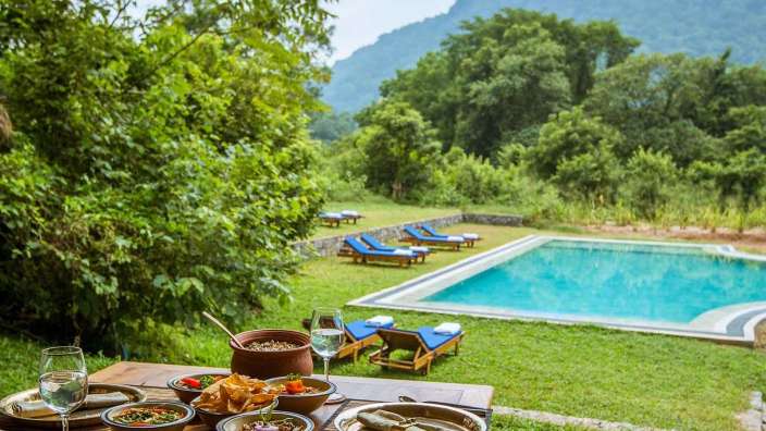 Ein Tisch mit Essen und einem Pool im Hintergrund