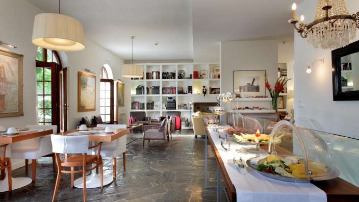 Ein Esszimmer mit Tischen und Stühlen und einem Buffet