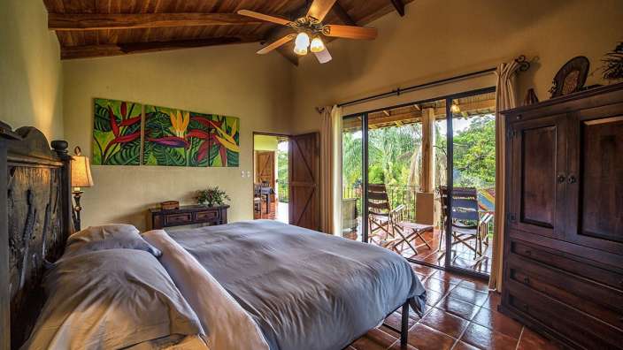 Ein Schlafzimmer mit einem Bett und einem Deckenventilator