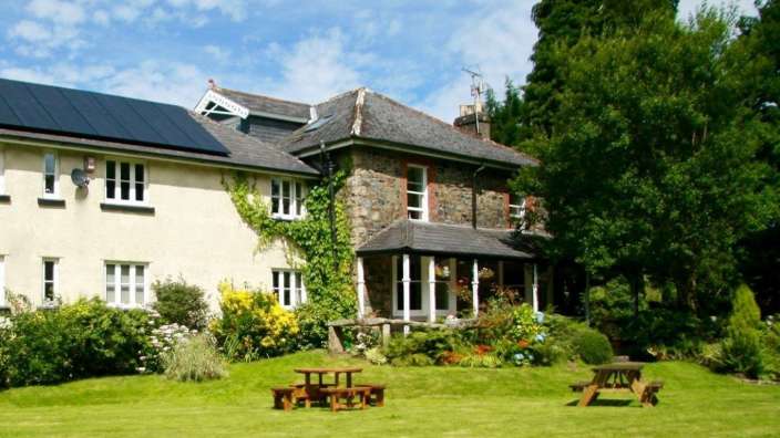 Ein großes Haus mit einem Picknicktisch im Vordergrund