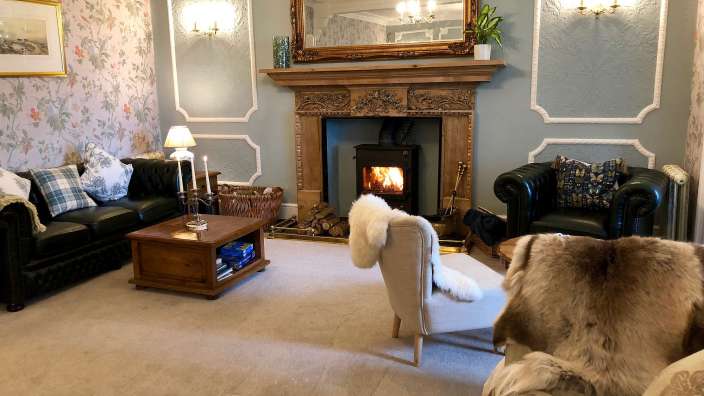 Ein Wohnzimmer mit einem Kamin und zwei Stühlen