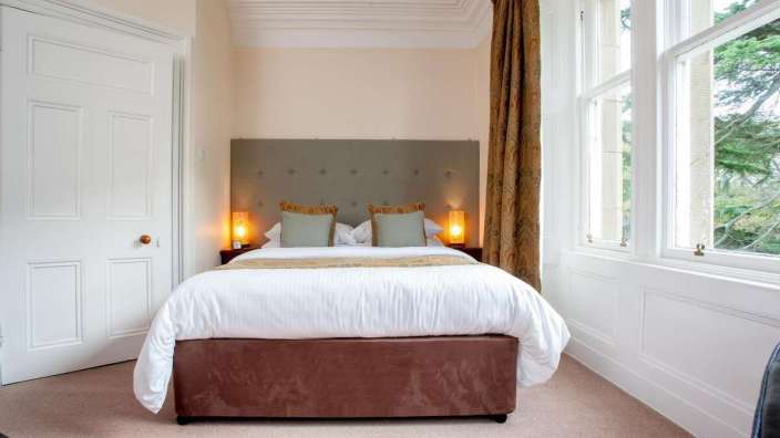 Ein Schlafzimmer mit einem Bett und zwei Fenstern