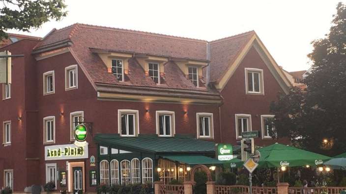 Ein großes braunes Gebäude mit einem grünen Dach und einem Schild mit der Aufschrift kron-platz