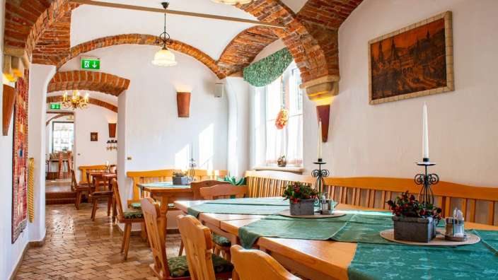 Ein Esszimmer mit Tischen und Stühlen und einem Bild an der Wand