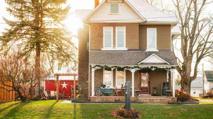 Ein braunes Haus mit zwei Fahrrädern auf der Veranda