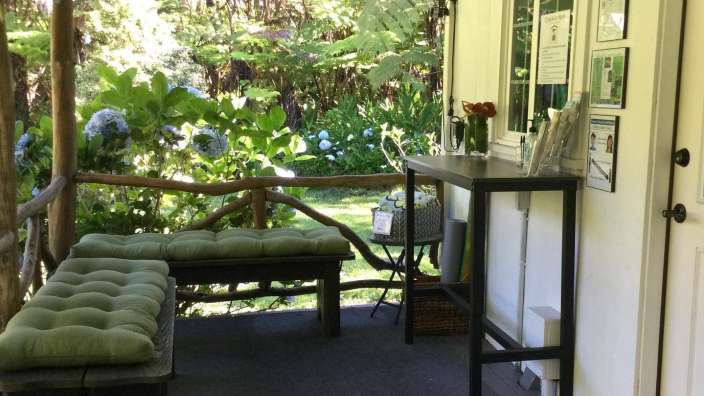 Eine Veranda mit grünen Kissen und einem Tisch