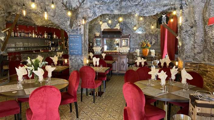 Ein Speisesaal mit roten Stühlen und Tischen