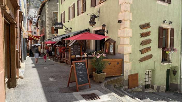 Eine kleine Straße mit einem Schild an der Seite, das sagt ' l' ermitage de la montagne '
