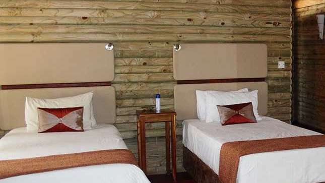 Ein Schlafzimmer mit zwei Einzelbetten und einer Holzwand .
