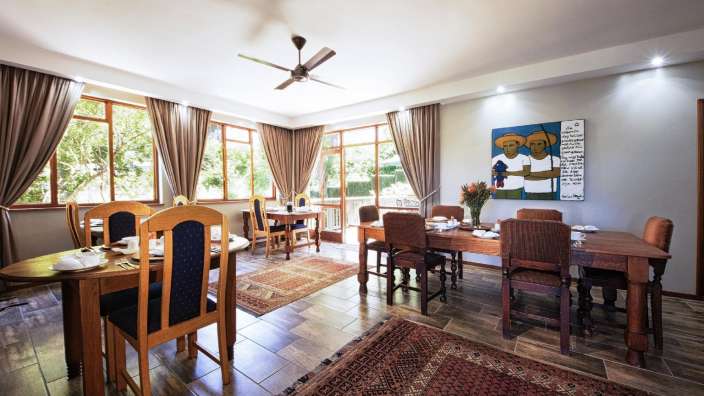 Ein Esszimmer mit Tischen und Stühlen und einem Gemälde an der Wand