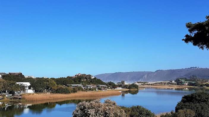 Ein Fluss mit Bäumen und Häusern am Ufer