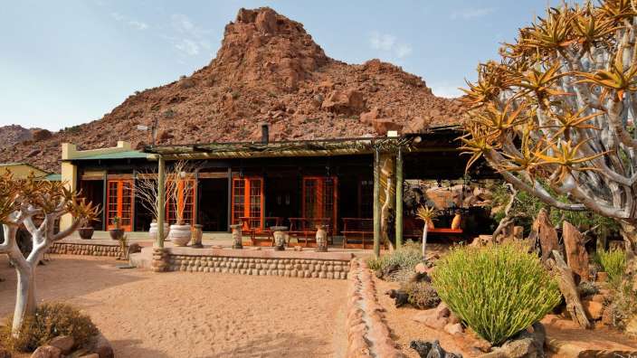 Ein Haus mit einem großen Felsen im Hintergrund