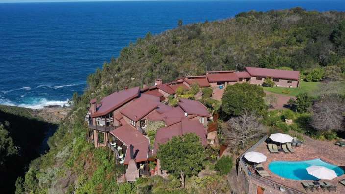 Eine Luftaufnahme eines großen Hauses mit einem Pool in der Nähe des Ozeans