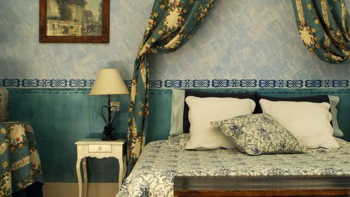 Ein blau-weißes Schlafzimmer mit einem Bett und einer Lampe