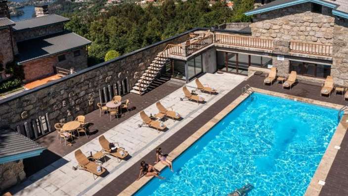 Eine Frau sitzt auf einem Stuhl neben einem Swimmingpool