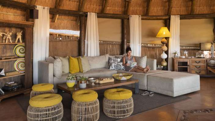 Eine Frau sitzt auf einer Couch und liest ein Buch